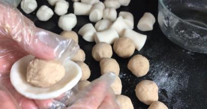 把冰皮捏成薄饼皮，放入莲蓉馅，收口