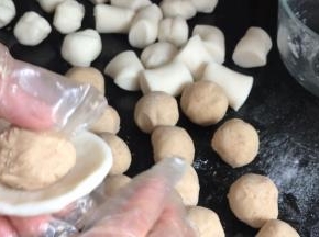 把冰皮捏成薄饼皮，放入莲蓉馅，收口