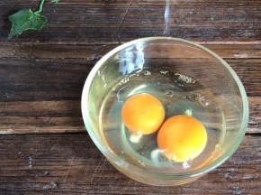 鸡蛋打入碗中，淋入料酒