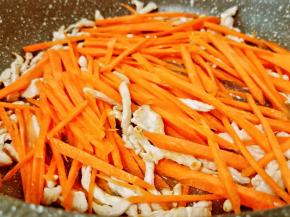 猪肉炒香后加胡萝卜丝翻炒。