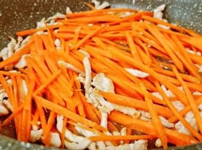 猪肉炒香后加胡萝卜丝翻炒。