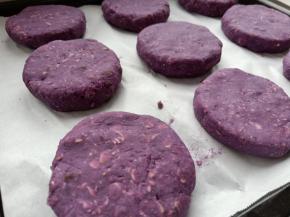 烤盘铺一张油纸，把做好的紫薯饼摆放到烤盘上，同时烤箱160度预热