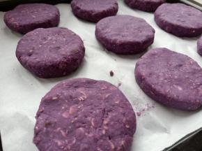 烤盘铺一张油纸，把做好的紫薯饼摆放到烤盘上，同时烤箱160度预热