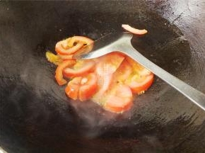 首先热锅冷油，升温后，把蒜瓣去皮切片爆香，番茄切小块也倒入锅中翻炒。