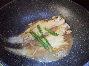 最后把小葱整把放入鱼上，加盖继续煮制一会，盛出就可以食用了。