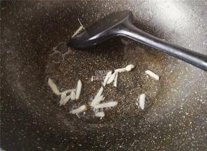 热锅冷油，把蒜瓣去皮切片，放入锅中爆香。