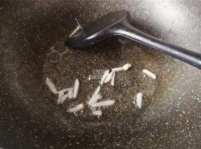 热锅冷油，把蒜瓣去皮切片，放入锅中爆香。