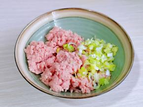 将肉糜取出放入大口器具中。加入切好的葱花，姜末。