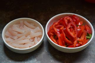 夹好猪毛的猪皮切成长条，青红椒切圈