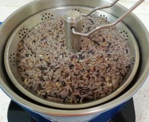 10分钟以后断电打开锅盖，这就是煮过的糙米饭，按一下上升/下降按键，将升降电火锅的提篮升起夹出来，倒掉煮过米的汤水。