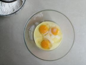 鸡蛋磕入打蛋盆里，倒入炼乳拌匀