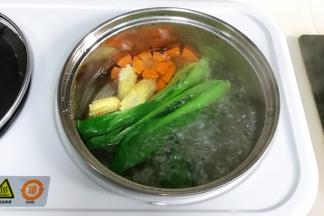 把油菜、玉米笋和胡萝卜片下沸腾的锅中焯熟，玉米笋可以多煮一会，然后捞出铺在面条上。