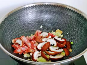 加入香菇与腊肠片煸炒。