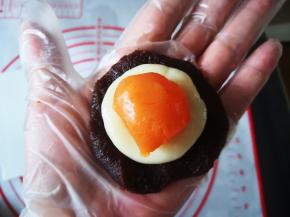 将咸蛋黄和麻薯叠在一起，包入豆沙中