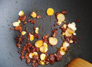 加入大料和花椒粒炒香，加入姜、蒜片，炒香。