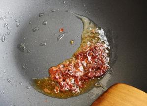 炒锅中加入食用油，加入郫县豆瓣酱炒出红油。