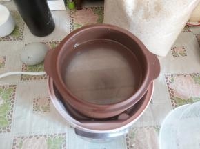 大米洗净，放入隔水炖内，倒入清水，八分满。