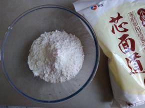 酵母和细砂糖倒入温水里，用筷子搅拌至全部溶解，奶粉和面粉倒入和面盆中，将酵母水和油倒入面粉里，用筷子拌成絮状