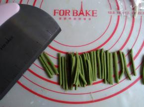 将绿色面团用擀面棍擀成长方形，用切面刀切成若干长条