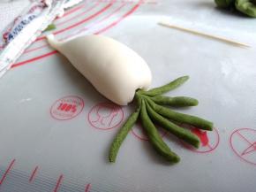 借助牙签将绿色的叶茎插入萝卜顶部