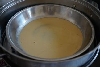 锅里的水烧开后，放上不锈钢碟子，先勺入一勺红糖粉浆，盖上锅盖，隔水蒸5分钟至凝结