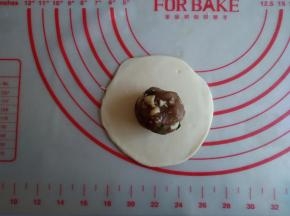 将每一份都擀成圆形，中间厚，四周薄，放上馅料