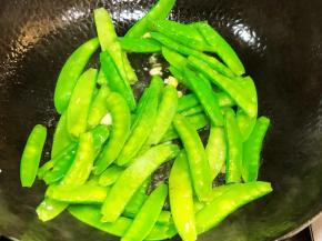 油锅放入蒜蓉和兰豆炒至7分熟，出锅备用