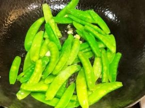 油锅放入蒜蓉和兰豆炒至7分熟，出锅备用