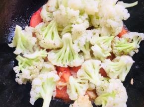 放入焯好水的花菜翻炒均匀。