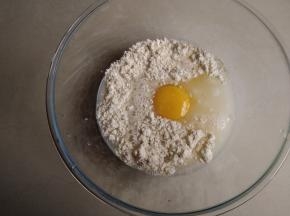 将低筋面粉、鸡蛋、清水和盐都倒入和面盆里