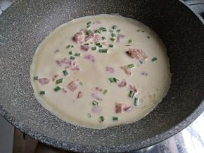 不粘平底锅里刷一层油，油不能太多，否则面糊很快成型，摊不圆。开小火加热不粘锅，不要用大火哟。然后将面糊勺进锅里，转动一下锅，使鸡蛋饼摊成圆形。这个分量可以做4块面饼