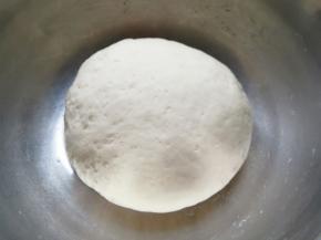 分次加入水，先用筷子挑拌成絮状，再揉成面团，盖上保鲜膜发酵至两倍大。