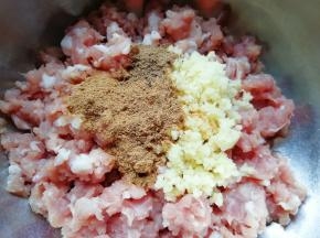 准备好肉馅，放上剁碎的生姜、十三香和花椒粉。