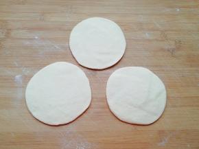 擀成中间稍厚边缘薄的包子皮。