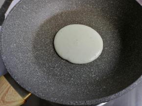 开中火热锅1-2分钟，这里用到的是不粘平底锅，这样煎出来的松饼上色才漂亮。转小火，我用的是煤气炉，小火指的不是只有中间火，而是两圈火力，不过火力是很微弱那种，不同炉具的火候控制会不一样。在锅的上方慢慢倒入蛋糕糊，形成自然的圆形，待表面出现气泡，就可以翻面了，大概煎了1分钟左右。