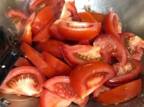 锅中倒入西红柿翻炒，加入适量的水