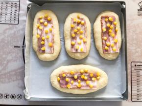 面包表面刷上蛋液，放上培根片，玉米（玉米提前煮熟）