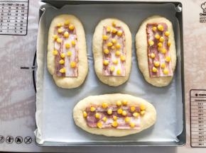 面包表面刷上蛋液，放上培根片，玉米（玉米提前煮熟）