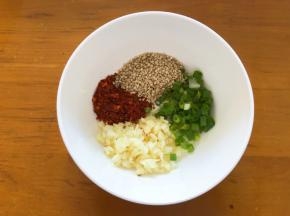 碗中放入芝麻，辣椒面，蒜末，香葱