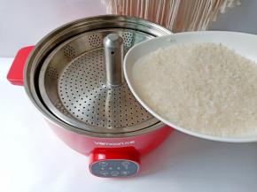 淘洗好的米放入升降盘里。