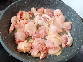 煮饭期间来炒鸡，锅中入油下大蒜、姜片煸炒、大火时加鸡块下锅快速煸炒。