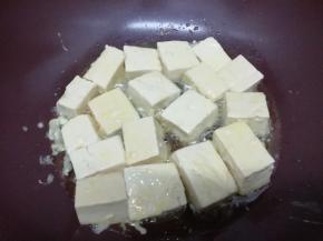 锅加入适量的油，烧到七成热时，把裹好鸡蛋液的豆腐放入锅中