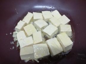 锅加入适量的油，烧到七成热时，把裹好鸡蛋液的豆腐放入锅中
