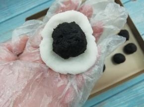 取一个山药球把它按扁，然后把枣泥馅放入中间，包好滚圆