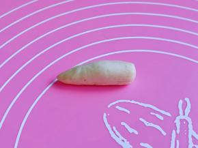 开始做蘑菇根啦！取一小块面团，用手心搓出一头尖的棒状，依次搓好。