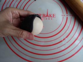 黑色面团粘在白色包子的1/2处，沾点水会更牢固