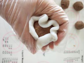 7.取面团擀成圆饼，包裹上内陷，捏紧收口。
