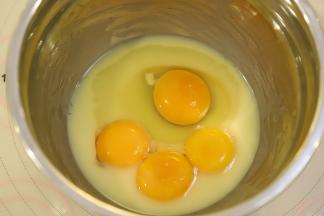 油温降至温热时磕入一个全蛋和3个蛋黄。