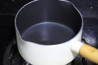 不粘锅内倒入清水，加入砂糖，煮沸。