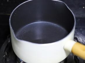 不粘锅内倒入清水，加入砂糖，煮沸。